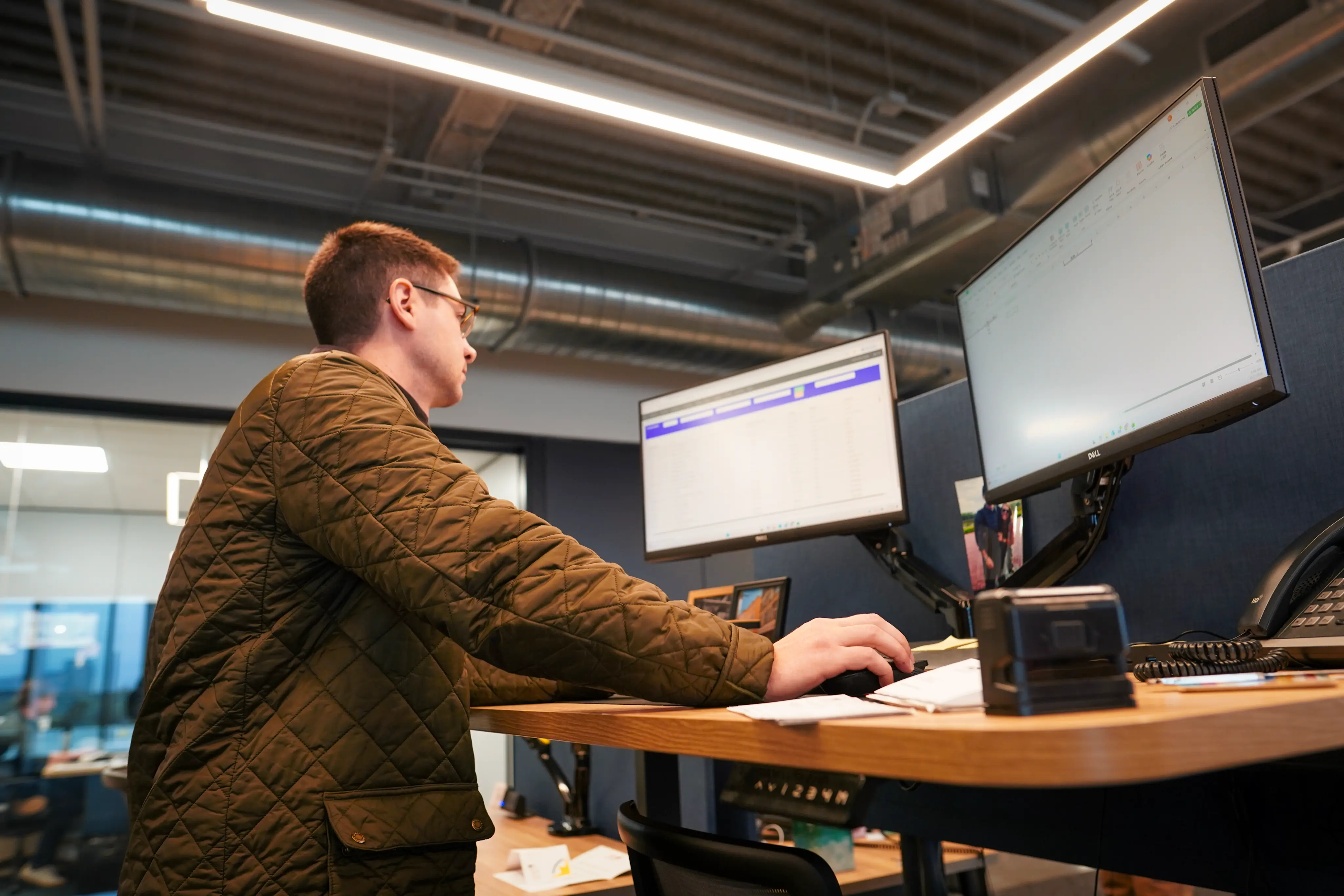 One person working at a desk with two monitors in front of him